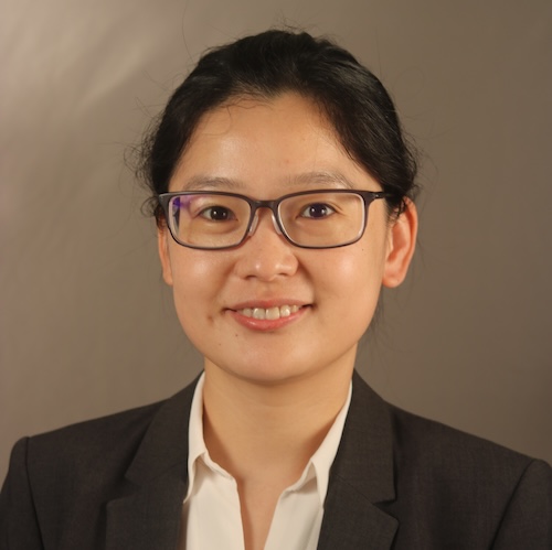 A woman standing in front of a grey background