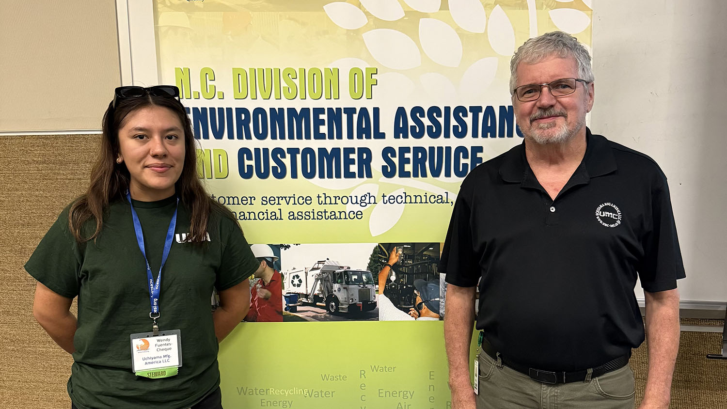 A man and a woman standing in front of a "N.C Division of Environmental Assistance and Customer Services"
