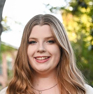 A woman smiling outside.